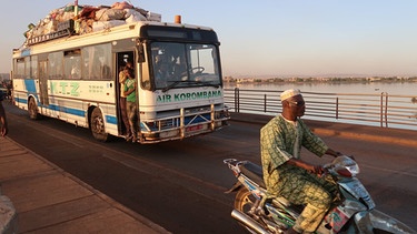 Bus und Motorradfahrer in Mali | Bild: Jonathan Fischer